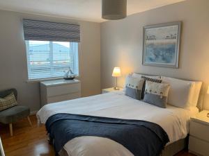 um quarto com uma grande cama branca e uma janela em Kintyre Apartment em Ayr