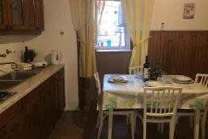 a kitchen with a table with chairs and a sink at Apartman Kadić Senj in Senj