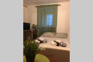 a bedroom with a bed with a green curtain at Apartman Kadić Senj in Senj