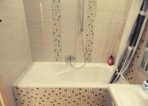 a bath tub with a shower and a sink at Апартаменти в Новому Будинку біля Софіївського Парку in Umanʼ
