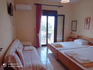 a bedroom with two beds and a balcony at Kandilari Apartments in Kókkinon Nerón