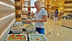 Seven Wonders Luxury Camp في وادي موسى: رجل واقف امام بوفيه طعام