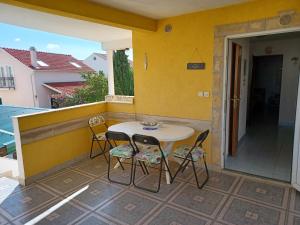 a table and chairs on the balcony of a house at Apartmani Jakovljevic in Murter