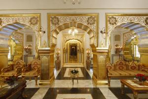 een grote kamer met 2 banken en een grote kamer met bij The Raj Palace (Small Luxury Hotels of the World) in Jaipur