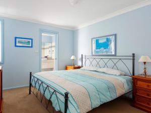a bedroom with a bed with blue walls at Aquarius Apartment 7 in Hawks Nest