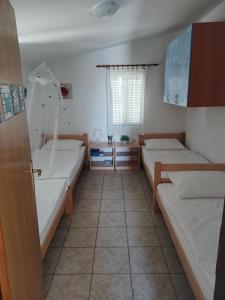 a room with two beds and a tub at Apartmani Jakovljevic in Murter