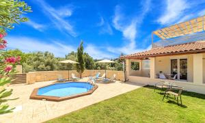 a backyard with a swimming pool and a house at Villa di Palma Heated Pool in Koúfi