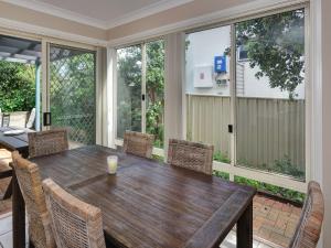 a screened in porch with a wooden table and chairs at Aquarius Townhouse in Hawks Nest