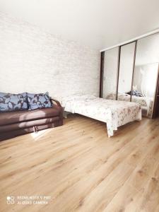 sala de estar con 2 camas y sofá en Елітна квартира в новобудові, en Leópolis