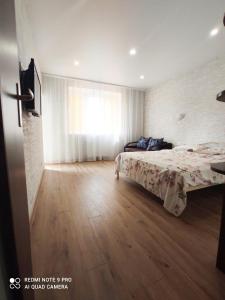 1 dormitorio con cama y ventana grande en Елітна квартира в новобудові, en Leópolis