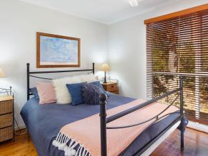 a bedroom with a bed and a window at Bennett's Beach Cottage in Hawks Nest