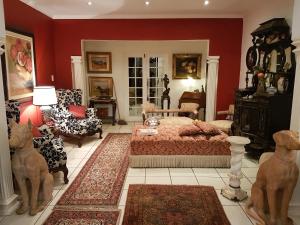 a bedroom with red walls and a bed and chairs at Michael-Angelo guest house in Potchefstroom