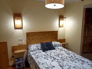 a bedroom with a bed with a blue and white comforter at Casa Rosalía in Silleda