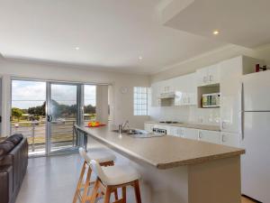 a kitchen with a white refrigerator and a counter top at Seachange Apartment 2 in Hawks Nest