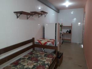 Dormitorio pequeño con cama y nevera en Praia da Maria, en Ubatuba