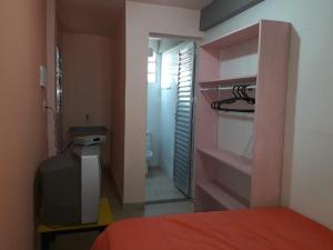 a bedroom with a bed and a door to a bathroom at Praia da Maria in Ubatuba