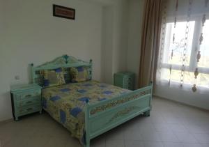 - une chambre avec un lit vert et 2 tables de chevet dans l'établissement Azure Residences, à Kelibia