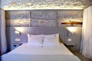 a bedroom with a bed with a blue wall at Keresbino Hydra Manor House in Hydra