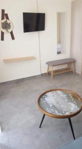 a room with a table and a tv on a wall at Athina View Studio in Néa Péramos
