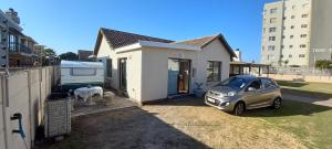 a small car parked in front of a house at Sea Cottage in Mossel Bay