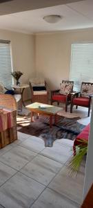 a living room with couches and a coffee table at Sea Cottage in Mossel Bay