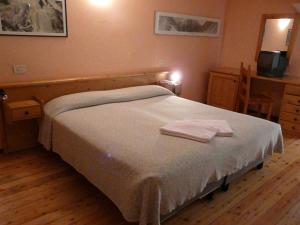 ein Schlafzimmer mit einem Bett mit zwei Handtüchern darauf in der Unterkunft À l'Hostellerie Du Paradis in Valsavarenche