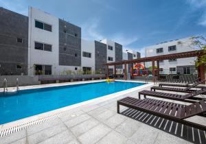 a swimming pool with lounge chairs in front of a building at Mabaat - White Pearl Al Basatin - 600 in Jeddah