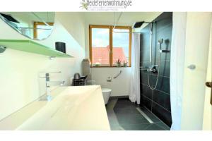 a bathroom with a sink and a toilet and a shower at heideferienwohnung - die neue Ferienwohnung in Walsrode