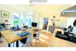 a living room with a large wooden table and chairs at heideferienwohnung - die neue Ferienwohnung in Walsrode