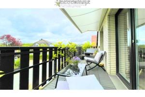 a balcony with a table and chairs on a house at heideferienwohnung - die neue Ferienwohnung in Walsrode