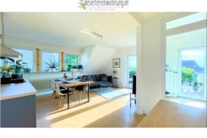 a kitchen and living room with a table and chairs at heideferienwohnung - die neue Ferienwohnung in Walsrode +1 photo