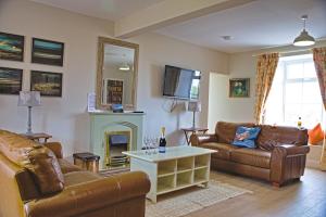 a living room with two couches and a fireplace at Arthur's Cottage in Dumfries