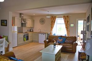 a kitchen and living room with a couch and a table at Arthur's Cottage in Dumfries
