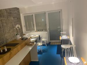 a kitchen with blue floors and white counters and chairs at Near Ortigia in Siracusa