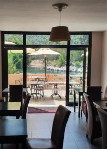 un restaurante con mesas y sillas y una gran ventana en Le Marina en Porto Ota