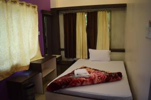 a small bed in a room with a window at The Imperial Hotel in Rādhākishorepur