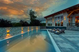 einen Pool mit zwei Stühlen und ein Haus in der Unterkunft Hotel Rhön Residence in Dipperz