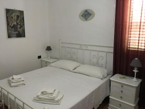 a bedroom with a white bed and two night stands at Villa dei Limoni sul Mare in Castellammare del Golfo