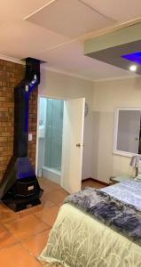Una habitación con chimenea y una cama en una habitación en Made Guest House en Sandton