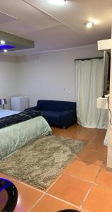 a room with a bed and a couch and a television at Made Guest House in Sandton