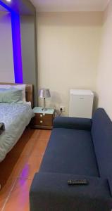 um quarto com uma cama e um sofá com um comando em Made Guest House em Sandton