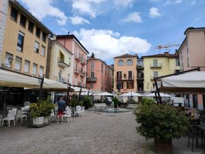 a person standing in a courtyard with tables and chairs at La Pentajota • camera con vista in Mondovì