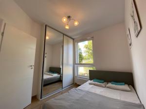 sypialnia z łóżkiem i dużym lustrem w obiekcie Kolska? best stay… w Warszawie