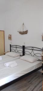 Una cama con sábanas blancas y almohadas. en Athina Studio Apartments, en Kerveli