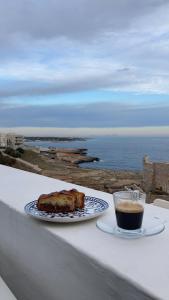 una mesa con un plato de comida y una taza de café en Casamare, en Polignano a Mare
