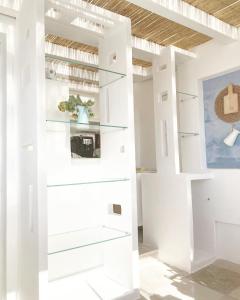 Habitación con paredes y estanterías blancas en Casamare, en Polignano a Mare
