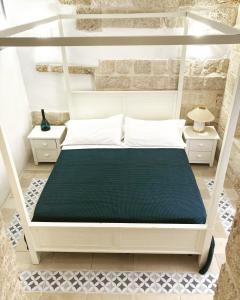 1 dormitorio con 1 cama blanca y 2 mesitas de noche en Casamare, en Polignano a Mare