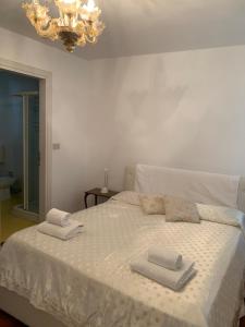a bedroom with a white bed with towels on it at Ca' Frezzeria in Venice