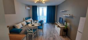 een woonkamer met een bank en een tafel bij A-33-Sea View Studio Apartment Sarafovo in Boergas