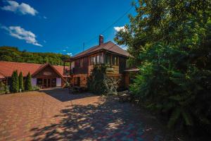 a house with a brick driveway in front of it at La Ferma Veche Bogdana in Bogdana